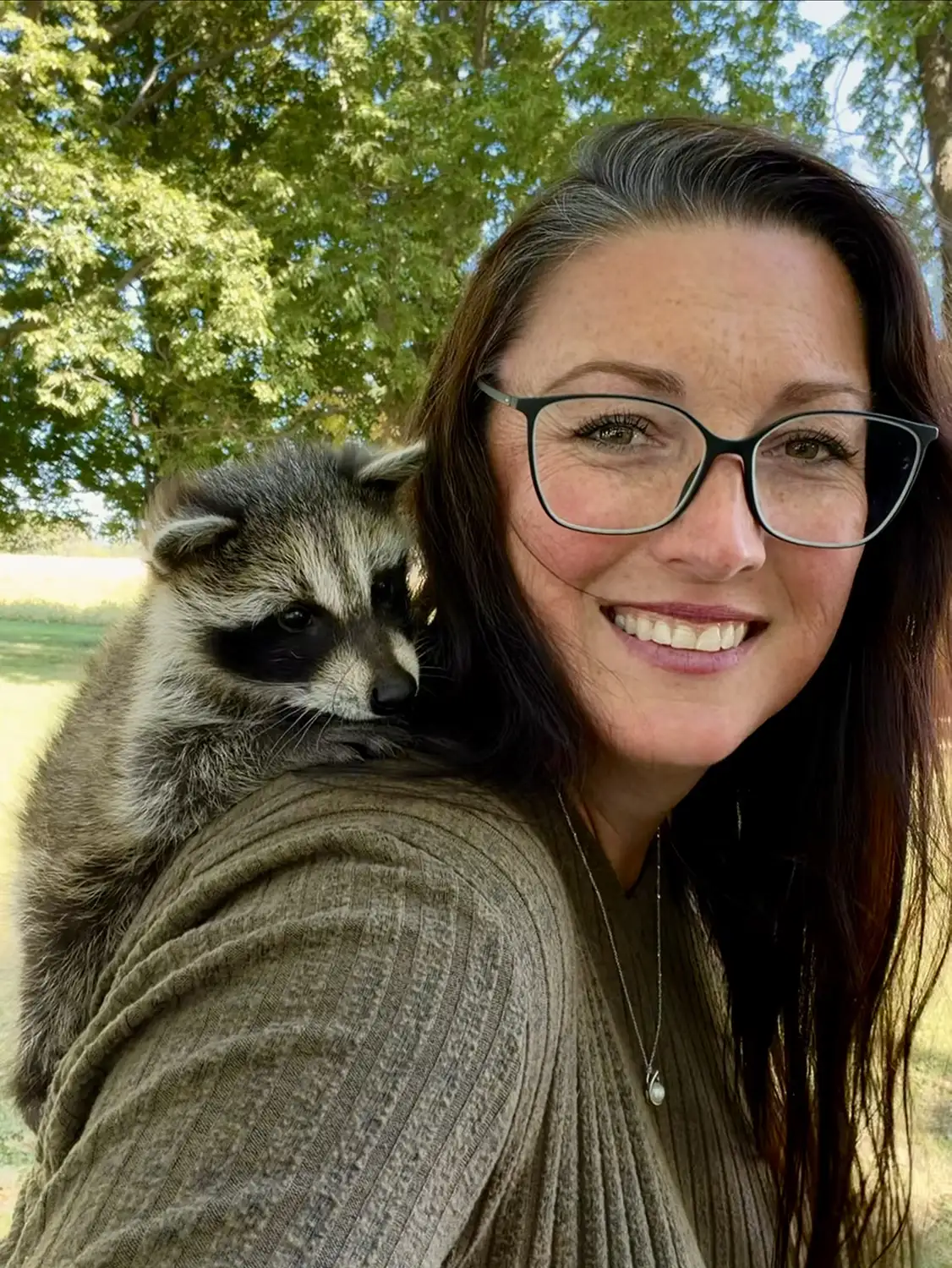Tanya pictured with a baby racoon on her shoulder